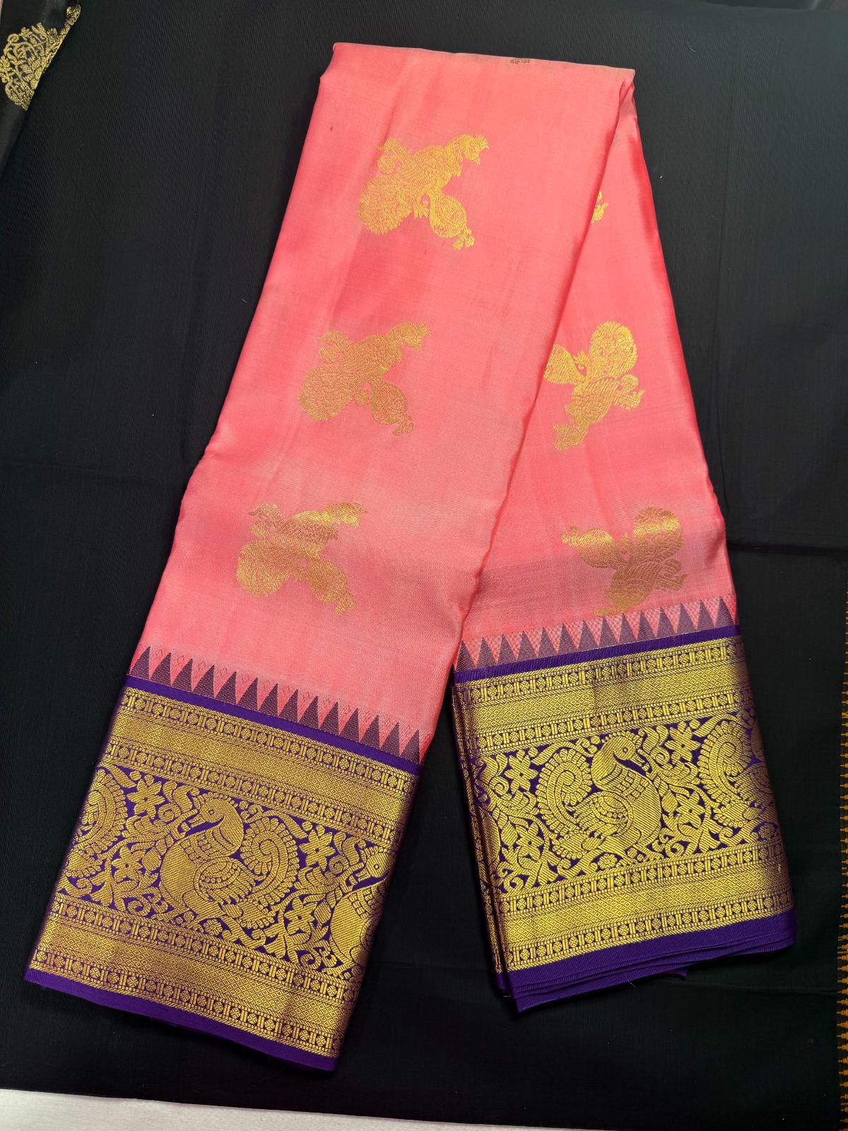 Pink pure kanjivaram pattu with peacock and veena butas all over, purple border and peacock, rudraksha and temples in border