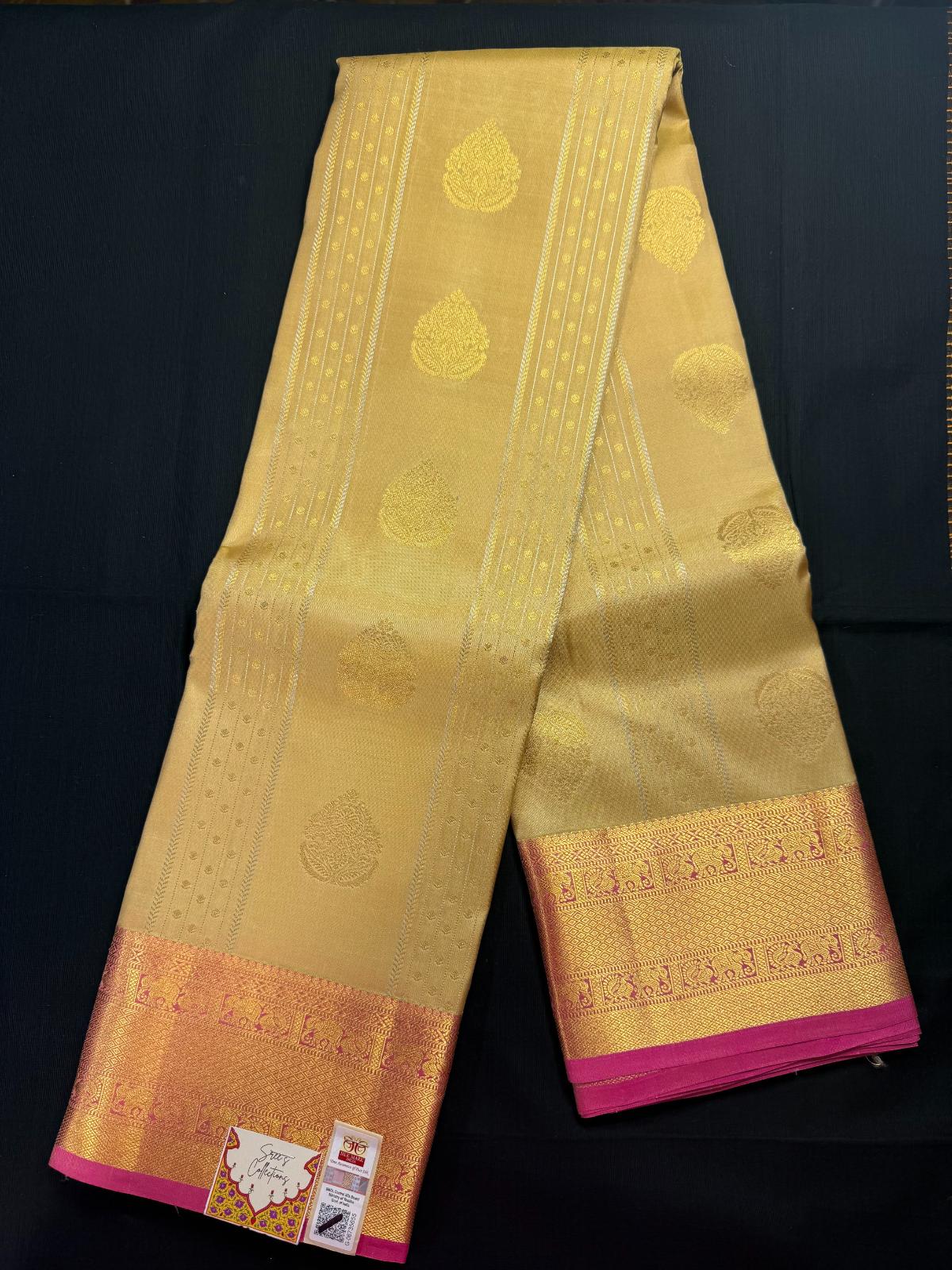 Beige Pure Kanjivaram Pattu with all over lines and goldand silver butas, with elephant and peacock in pink border