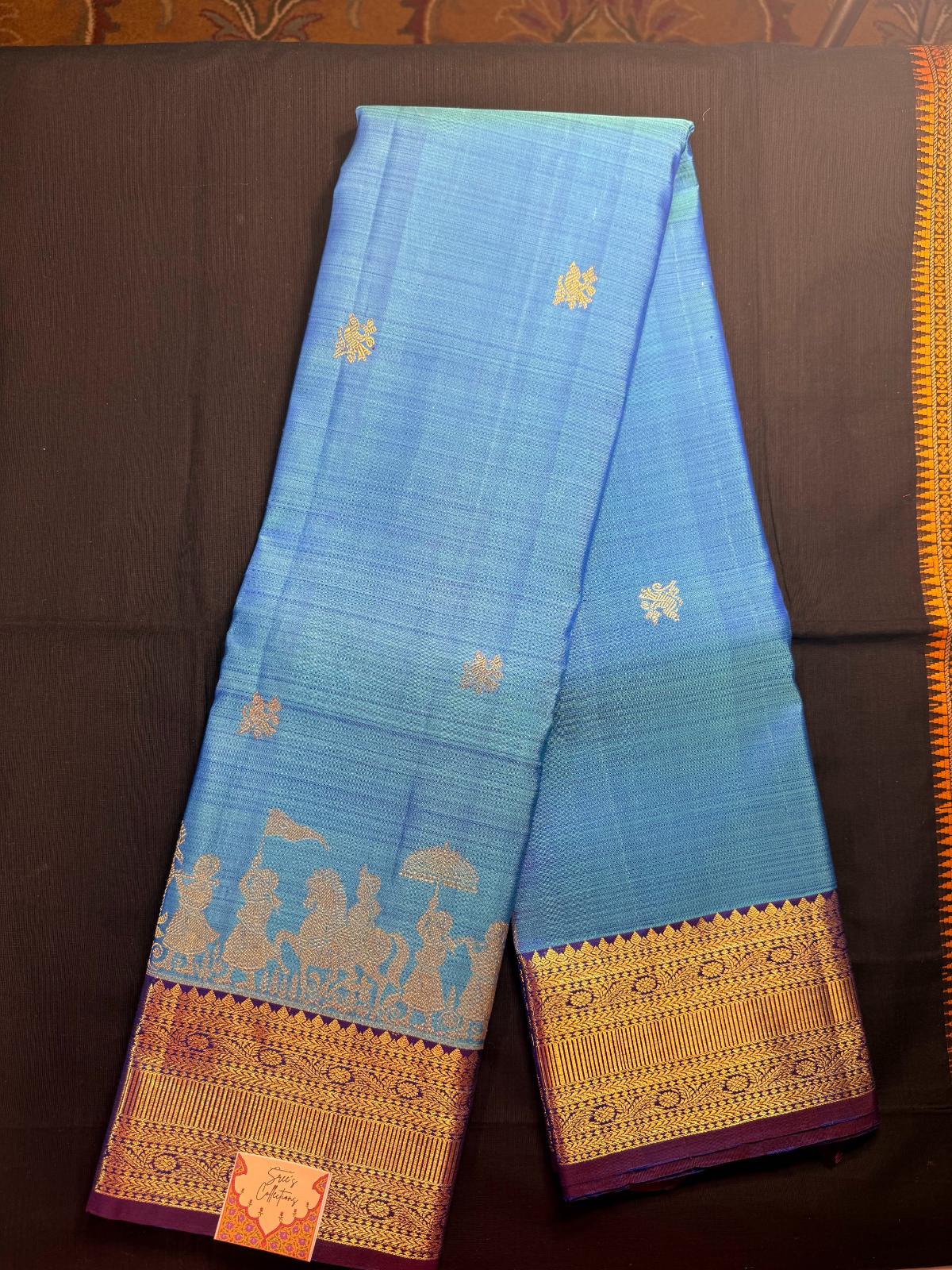 Sky blue, with peacock butas all over, pallaki design with purple border including rudrakshas
