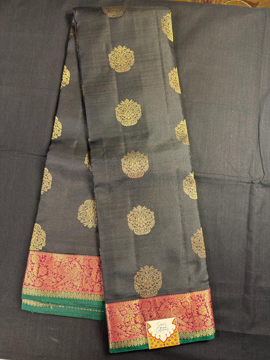 Black Pure Kanjivaram Pattu with all over butas and maroon and green border with peacocks
