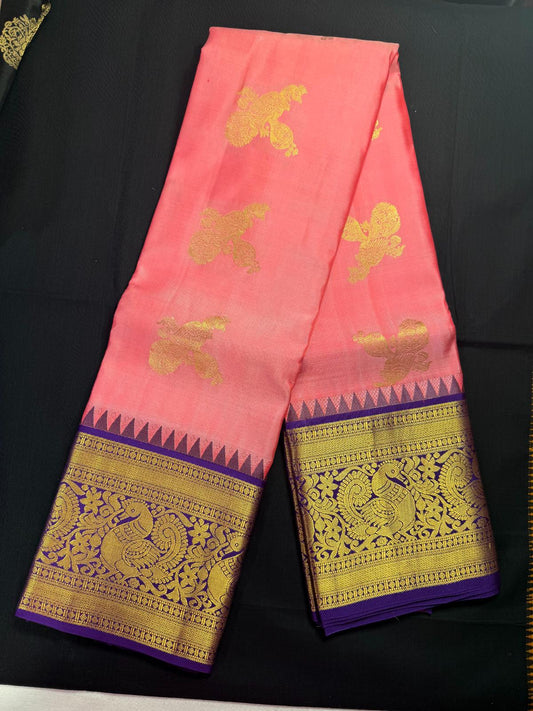 Pink pure kanjivaram pattu with peacock and veena butas all over, purple border and peacock, rudraksha and temples in border