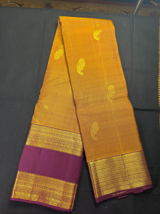 Mustard pure kanjivaram pattu with jari peacock butas all over, maroon gap border and small border combination
