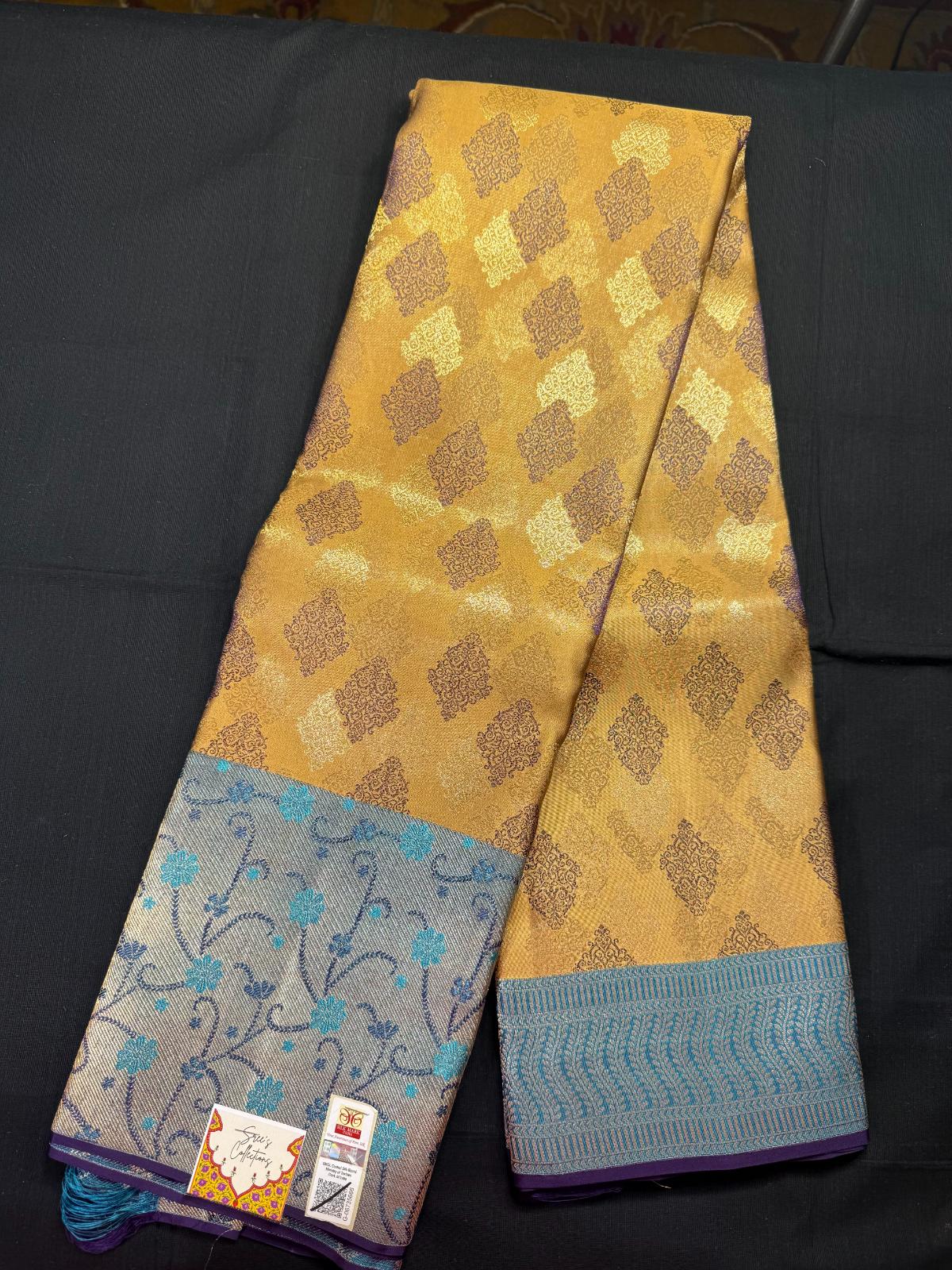 Dark beige pure kanjivaram pattu with all over jacquard, purple, silver and jari butas, blue meenakari border, with skyblue and dark blue leharia design