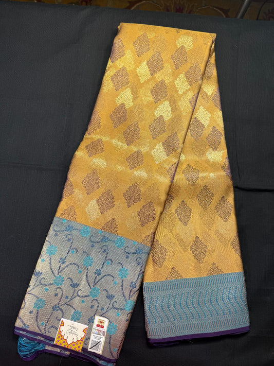 Dark beige pure kanjivaram pattu with all over jacquard, purple, silver and jari butas, blue meenakari border, with skyblue and dark blue leharia design