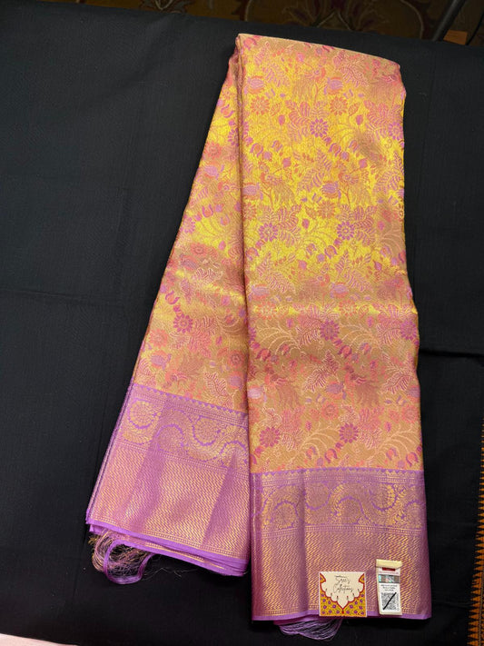 Gold pure kanjivaram pattu with meenakari design, jacquard, peacok and flowers, purple border with rangoli design